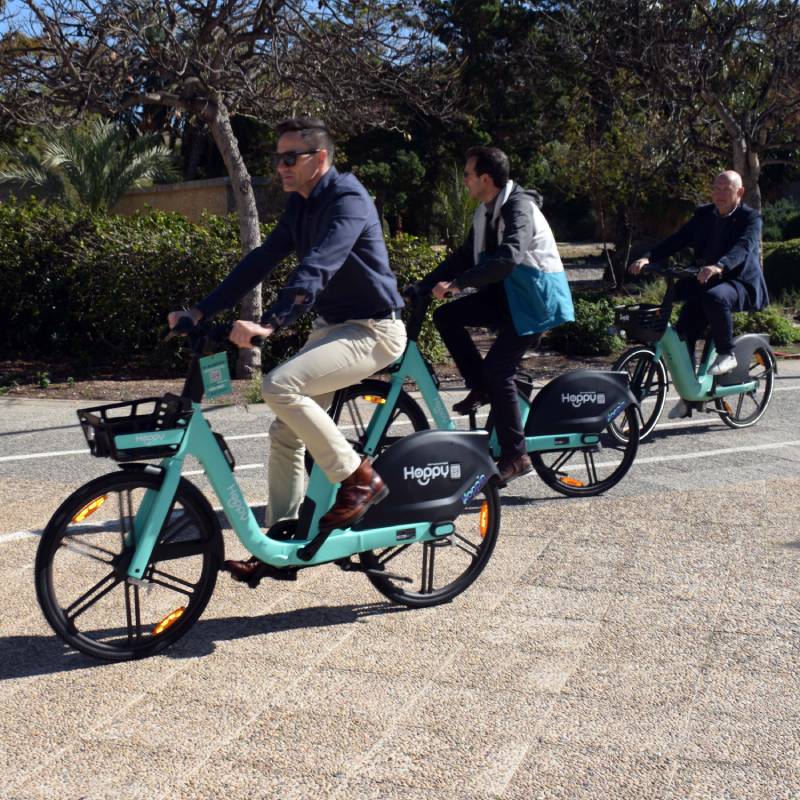 Tres profesionales desplazándose en bicicleta eléctrica por una calle de Almería