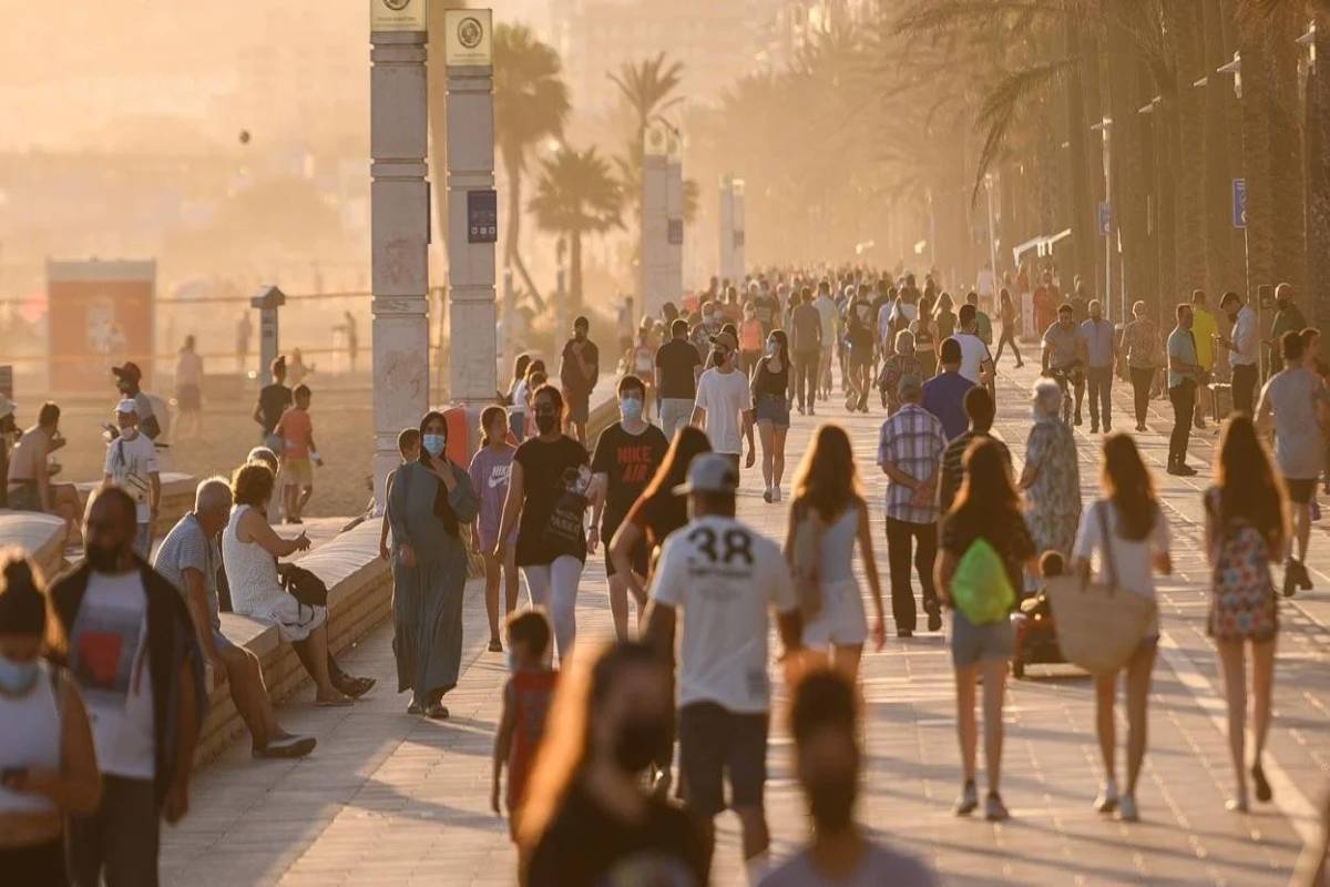 Personas paseando por el paseo marítimo de Almería al atardecer disfrutando del clima y la vida al aire libre